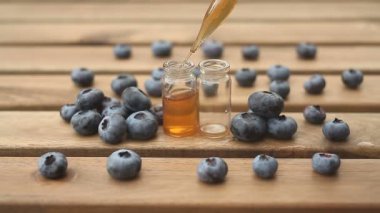 Güzel cam kavanoz ahşap arka plan üzerinde yaban mersini Özü