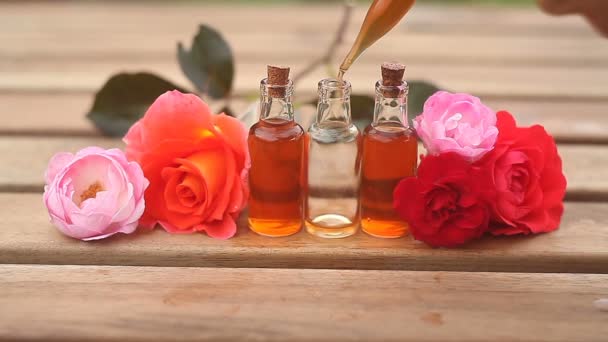 美しいガラスの瓶の中のテーブルの上のバラのエッセンス — ストック動画