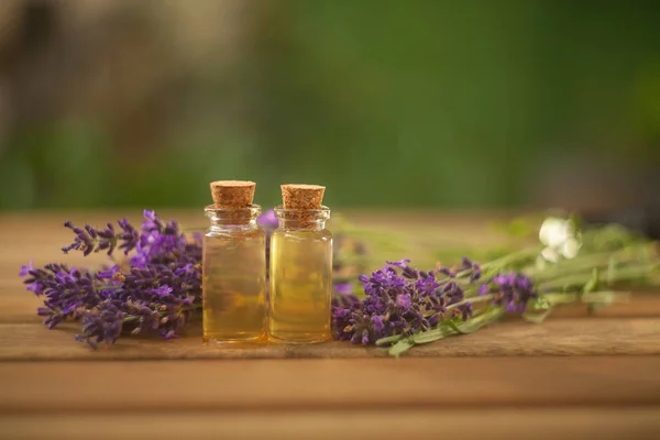 Aceite esencial de lavanda en una hermosa botella sobre la mesa — Foto de Stock