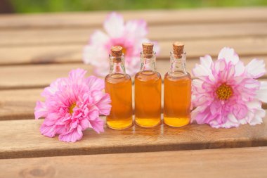 Çiçeklerin özü güzel bir cam şişede masanın üzerinde.