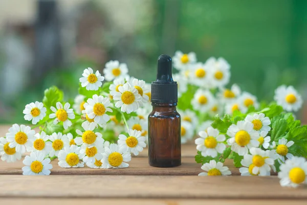 Esencia de flores en la mesa en vidrio hermoso Botella — Foto de Stock