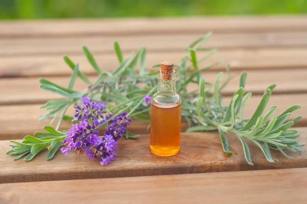 Aceite esencial de lavanda en una hermosa botella sobre la mesa — Foto de Stock