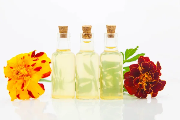 Aceite esencial de caléndula en hermosa botella sobre fondo blanco — Foto de Stock
