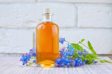 Çiçeklerin özü beyaz bir arka planda güzel bir cam kavanozda