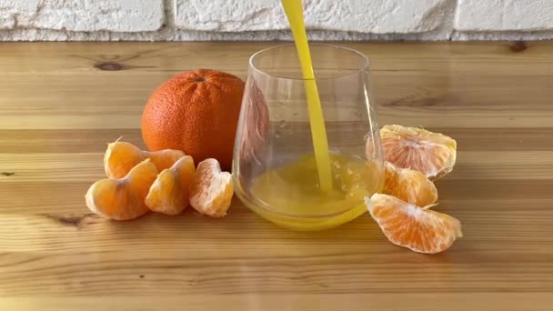 透明ガラスの中でおいしい新鮮な絞りみかんジュース — ストック動画