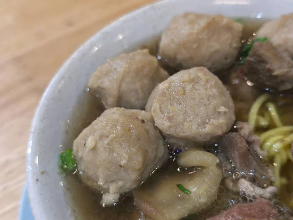 Yakın plan çekimde iştah açıcı bir kase bakso, popüler bir Endonezya köfteli şehriye çorbası, bol et suyu ve taze yeşil soğanlı