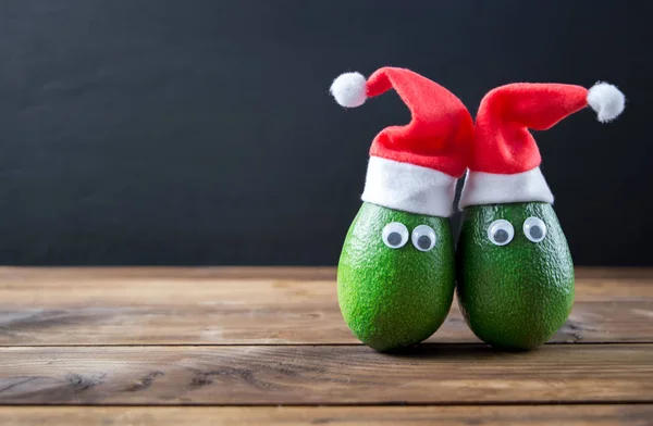 Weihnachten Avocado Paar. Avocado im Weihnachtsmütze lizenzfreie Stockfotos