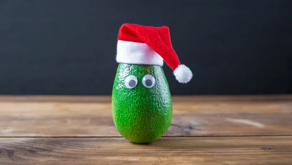 Weihnachten Avocado. Avocado in Weihnachtsmütze. Urlaubskonzept Stockbild