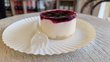 Lezzetli böğürtlen kompostosu ile kaplı kremalı peynirli pastanın tadını çıkar.