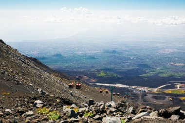 Sicilya 'daki Yanardağ Etna. Köye bir bak. Siyah volkanik kum, volkanik taşlar, şehir manzarası. Sicilya. Volkan ve bulutlar. Teleferiğin görüntüsü.