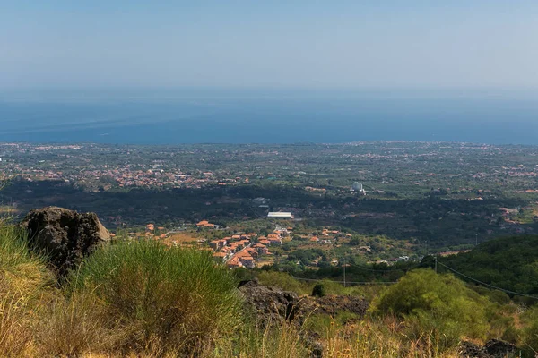 İtalyan küçük kasabası. Siyah volkanik kum, volkanik taşlar, orman manzarası. Taormina. Sicilya. Dağlarda ve bulutlarda orman. Yer, bitkiler, bulutlar, sonbahar günü