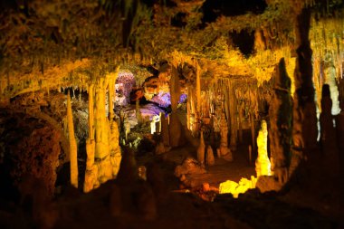 İspanya 'da Mallorca adasındaki Stalactite aydınlatmalı mağaralar. Mağaraların çok renkli aydınlatması. Güzel mağara. Eski mağaradaki sarkıtlar. Kırmızı, yeşil, mavi, mor, sarı.