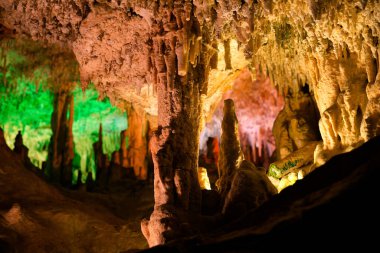 İspanya 'da Mallorca adasındaki Stalactite aydınlatmalı mağaralar. Mağaraların çok renkli aydınlatması. Güzel mağara. Eski mağaradaki sarkıtlar. Kırmızı, yeşil, mavi, mor, sarı.