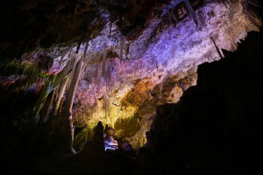 İspanya 'da Mallorca adasındaki Stalactite aydınlatmalı mağaralar. Mağaraların çok renkli aydınlatması. Güzel mağara. Eski mağaradaki sarkıtlar. Kırmızı, yeşil, mavi, mor, sarı.