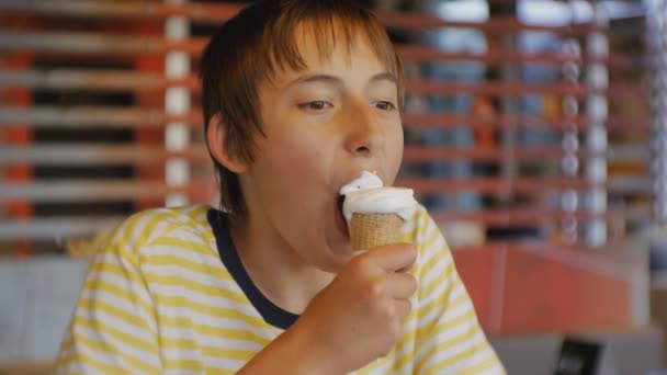 Подросток ест фастфуд. Портрет подростка, поедающего мороженое в ресторане быстрого питания . — стоковое видео