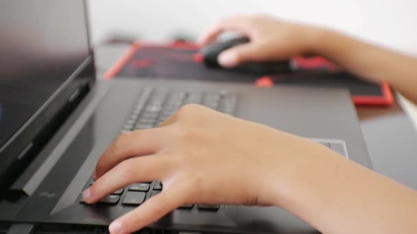 Підліток використовує ноутбук. Крупним планом руки підлітка натискають клавіатуру ноутбука . — стокове відео