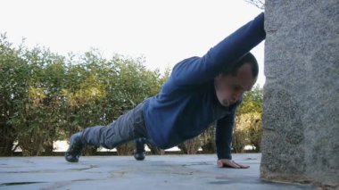 Kişisel antrenör açık havada ile egzersiz. Erkek atlet askeri tarzı çizmeler ve pantolon yapıyor kol şınav bir parkta bir egzersiz rutin bir parçası olarak büyüdü..
