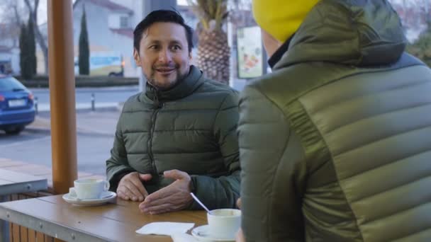 저녁에는 카페의 공간에서 따뜻한 재킷에서 이야기 수염을 남자는 운동에 말한다 — 비디오