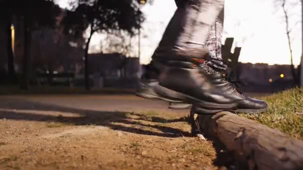 Entrenamiento con entrenador personal al aire libre. Primer plano de pies femeninos y masculinos en zapatillas de deporte haciendo step-ups juntos en un tronco bajo la luz de farolas en el parque después de la puesta del sol . — Vídeo de stock