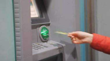 Para kullanan kadın. Kredi kartı Atm ekleme ve geceleri PIN kodunu girme kırmızı balonu ceketli el.