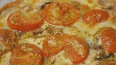Pişmiş pizza domates, peynir ve petrol ile yakın çekim.