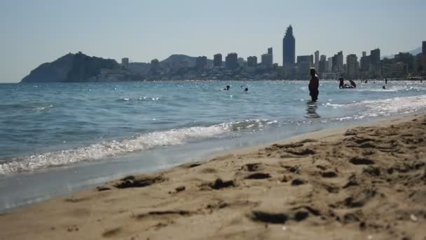 Linea costiera di spiaggia sabbiosa di giorno su sfondo skyline grattacielo . — Video Stock