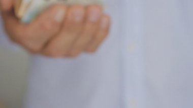 Euro notları tutarak hafif mavi gömlekli yaşlı adamın elini Close-up.