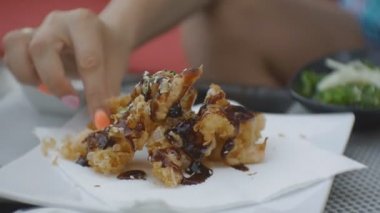 Close-up ısırma ve çiğneme tempura karides Japon restoran açık terasta çekici genç beyaz kadın.