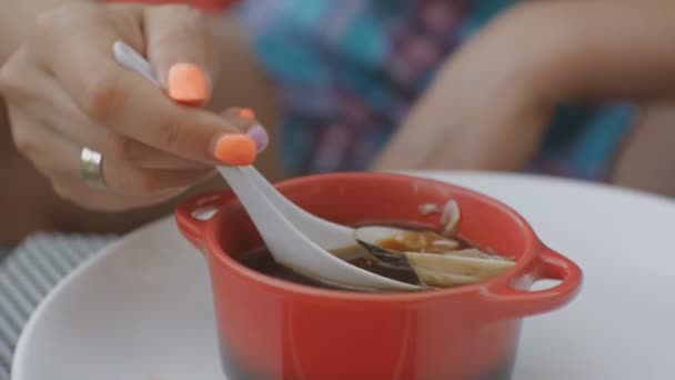 Primer plano de la atractiva joven caucásica comiendo sopa con moluscos en la terraza abierta del restaurante japonés . — Vídeos de Stock