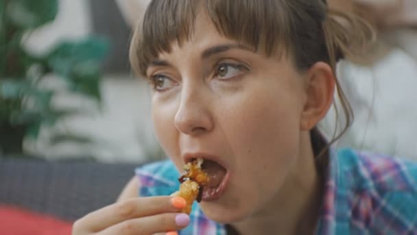 Close-up van aantrekkelijke jonge Kaukasische vrouw tempura garnalen eten op het open terras van Japans restaurant. — Stockvideo