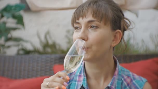 Porträt einer attraktiven jungen kaukasischen Frau, die Champagner auf der offenen Terrasse eines japanischen Restaurants probiert. — Stockvideo