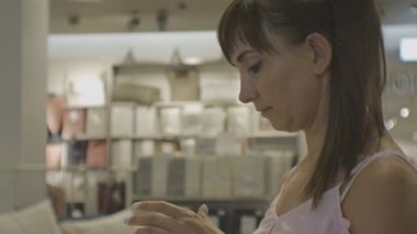 Çekici kadın ev dükkanda. Genç beyaz kadın Close-up aroma mum kokuyor.