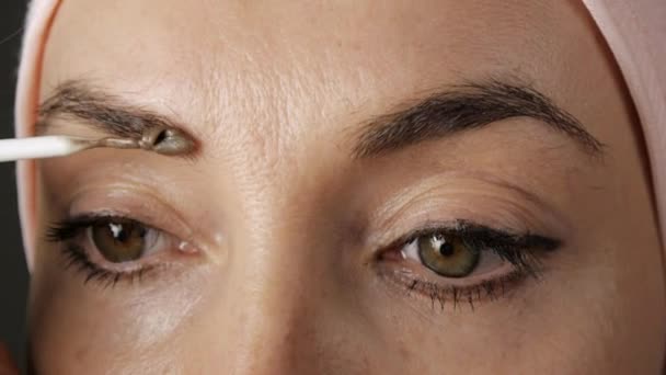 Tingimento de sobrancelhas. Close-up de aplicação de tinta marrom nas sobrancelhas . — Vídeo de Stock