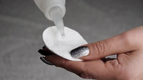 Close-up van vrouwelijke handen toepassing lotion op wattenschijfje. — Stockvideo