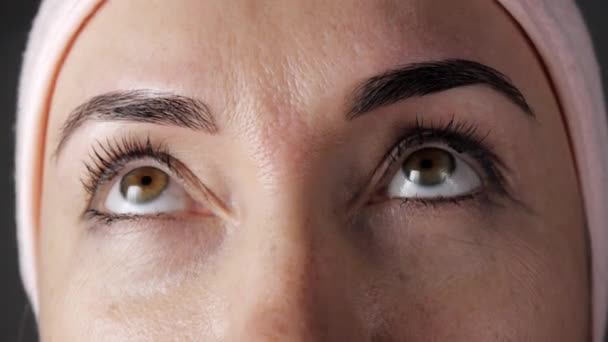 Close-up of young caucasian female face after cosmetic procedure. Womans eyes looking up. — Αρχείο Βίντεο