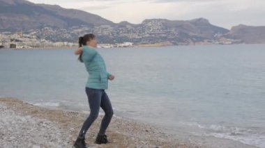 Kadın yalnız soğuk Plajı'nda. Kafkas kadın taş sakin denize atar..