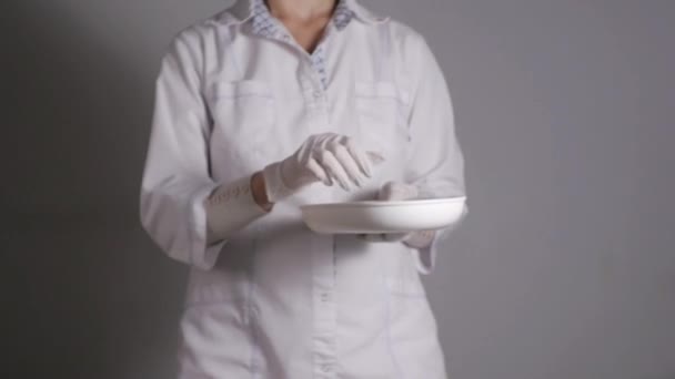 Doctora dando pastillas. Joven profesional médico da tabletas en un blister que toma de plato de riñón . — Vídeos de Stock