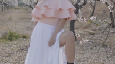 Çiçek Bahçe kadında. Seksi sarışın kadın model badem çiçeği bahar parkta poz orta çekim.