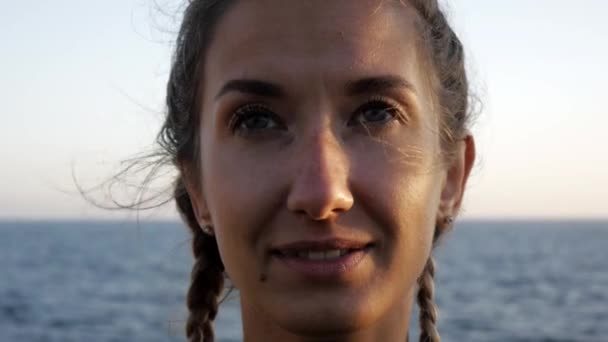 Giovane donna che fa esercizi. Primo piano di attraente ragazza caucasica che fa esercizio di respirazione yoga sul fondo del mare tramonto . — Video Stock