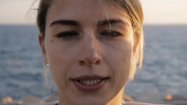 若い女性の演習を行います。魅力的なブロンド女性ヨガ呼吸サンセットの海の背景のクローズ アップ. — ストック動画