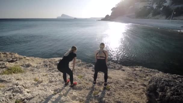 Duas jovens fazendo exercícios à beira-mar . — Vídeo de Stock