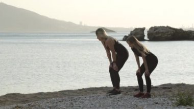 Deniz den egzersiz yapan iki genç kadın.