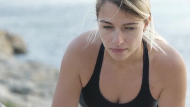 Mujer joven haciendo ejercicios junto al mar . — Vídeos de Stock