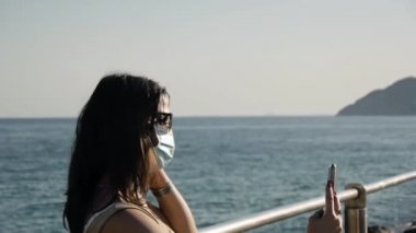 Yat limanında koruyucu maskeli genç bir kadın..