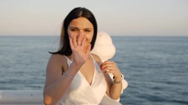 Deniz kenarındaki beyaz elbiseli genç kadın..