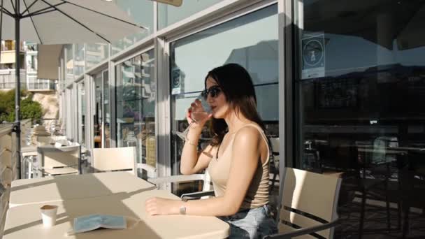 在咖啡馆阳台上的年轻女人. — 图库视频影像