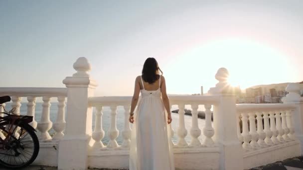 Jovem mulher de vestido branco à beira-mar. — Vídeo de Stock