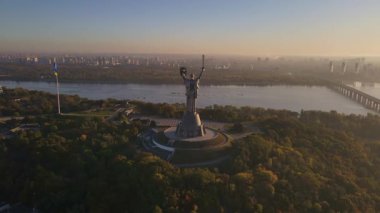 Ukrayna 'nın Ukrayna Ana Anıtı' nın Kyiv, Ukrayna 'daki havadan görünüşü, sıcak aydınlatma sırasında Dnipro Nehri, şehrin ufuk çizgisi ve park alanları görülebilir..