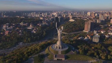 Ukrayna 'nın başkenti Ukrayna' nın başkenti Kyiv 'de bulunan ve zıpkını taşıyan kılıç ve kalkanla donatılmış bir anımın havadan görünüşü, altın saatinde şehir manzarasına karşı hazırlanıyor..