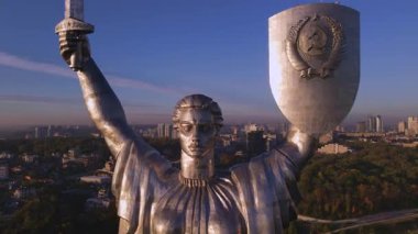 Ukrayna 'nın Ukrayna' nın başkenti Kyiv 'de şehir binaları ve yeşil alanlarla çevrili bir kılıç ve mızraklı kalkanla hava manzarası..